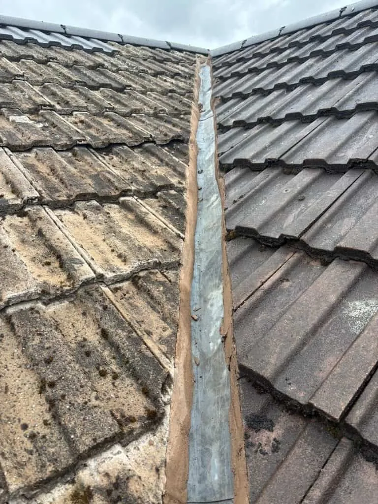 New roof tiles alongside old leadwork showing repair and restoration work