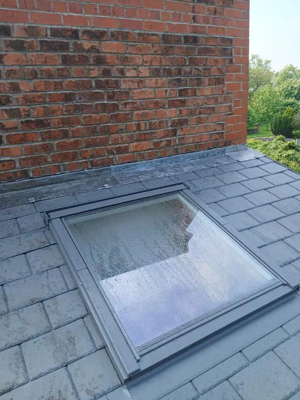 New roof tiles alongside old leadwork showing repair and restoration work