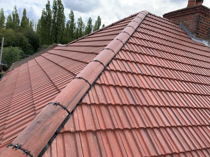 Clay tiles with new ridge tiles installed on residential property