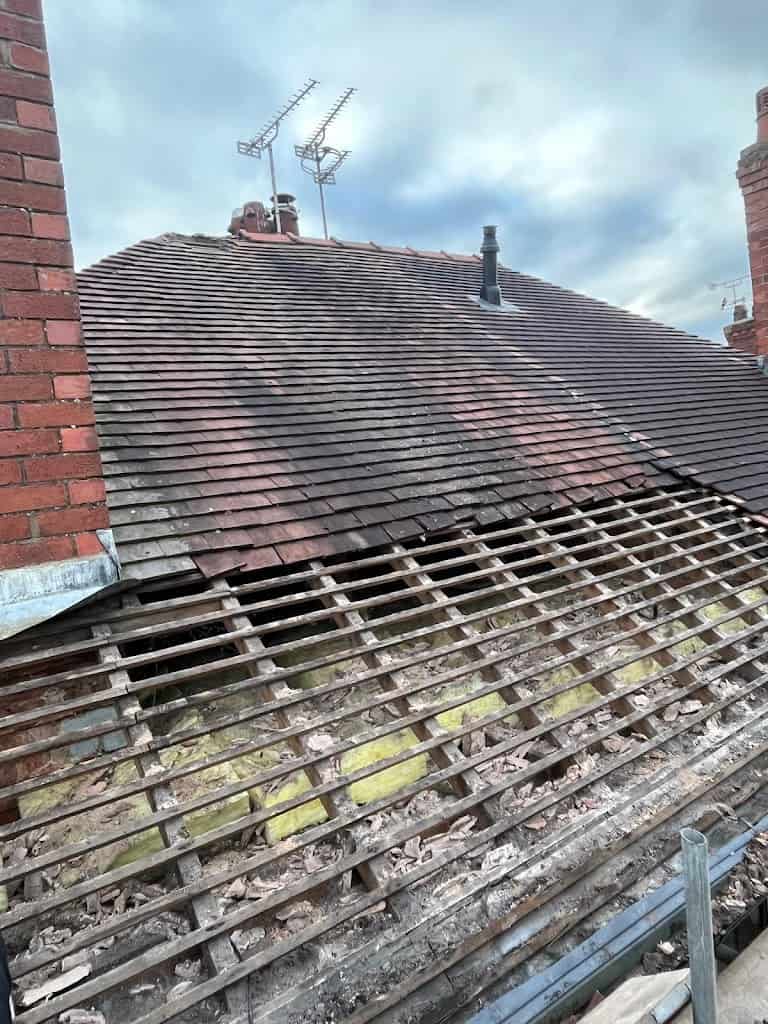 Old roof tiles being stripped to battens before re-roofing