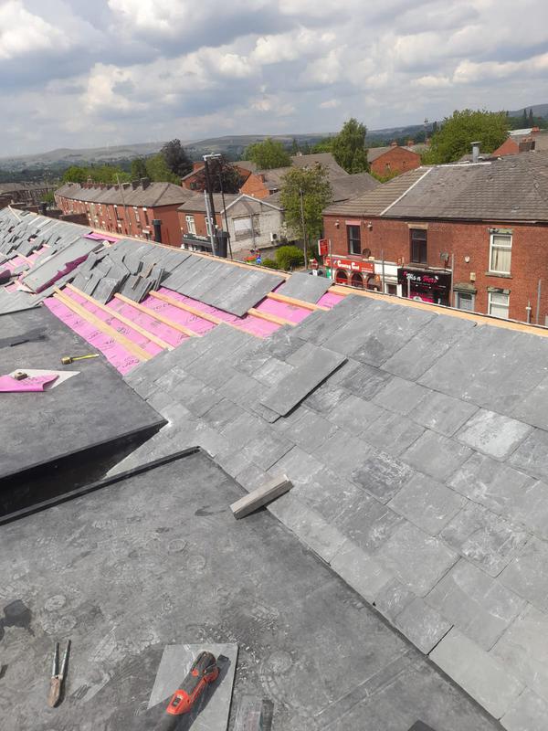 Slate tiles placed onto victorian-era terraced roof